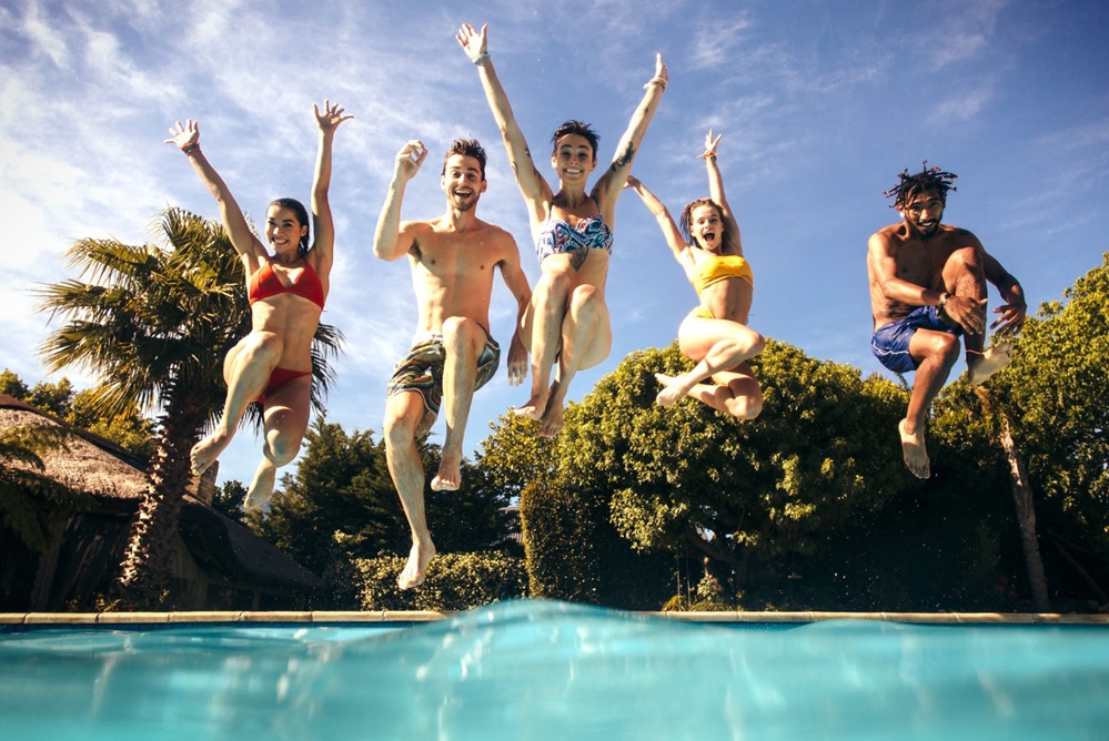 Group of Friends jumping into the pool