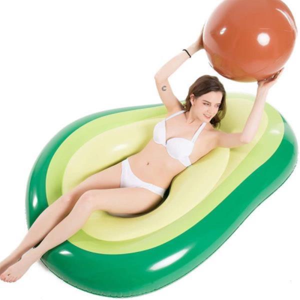 Woman lays in avocado pool float with pit ball